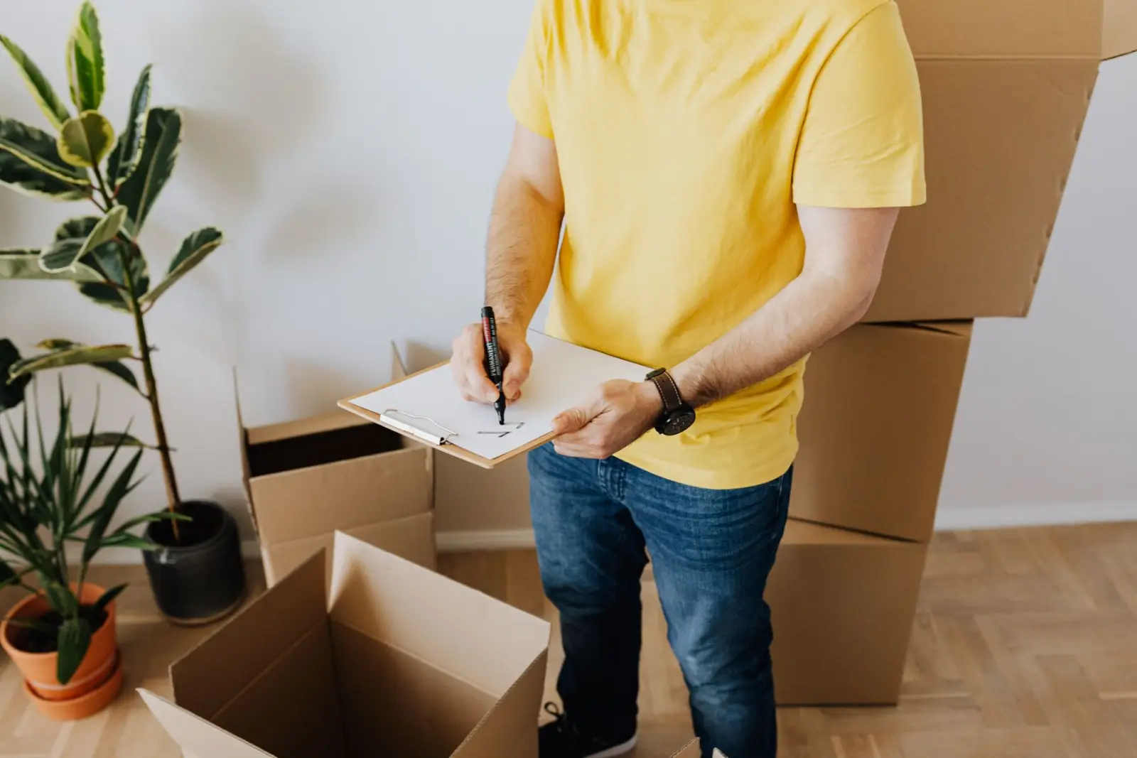 Planning a move with a checklist beside packed boxes