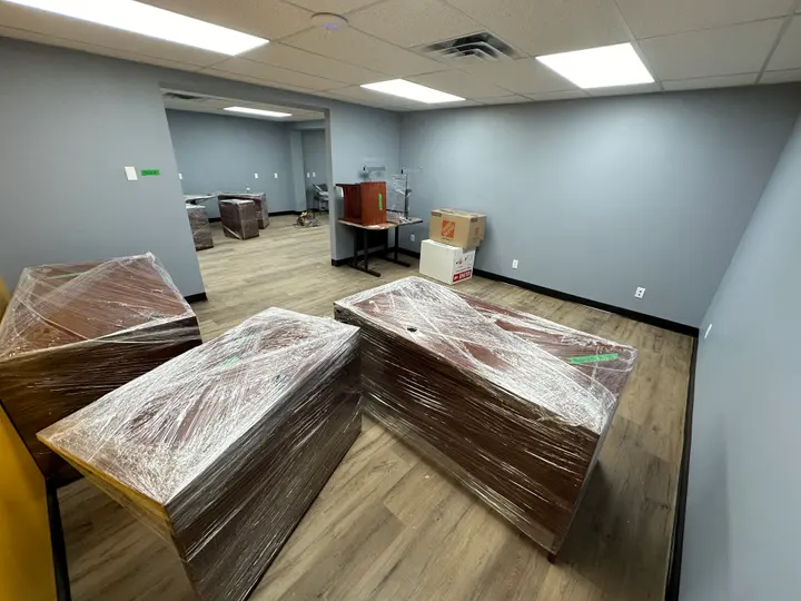 Desks and other office furniture wrapped and grouped for moving