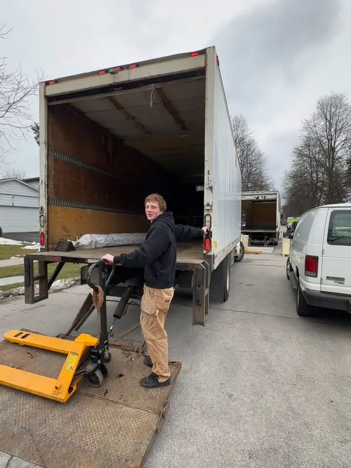 An Optimum crew member beside the open moving truck