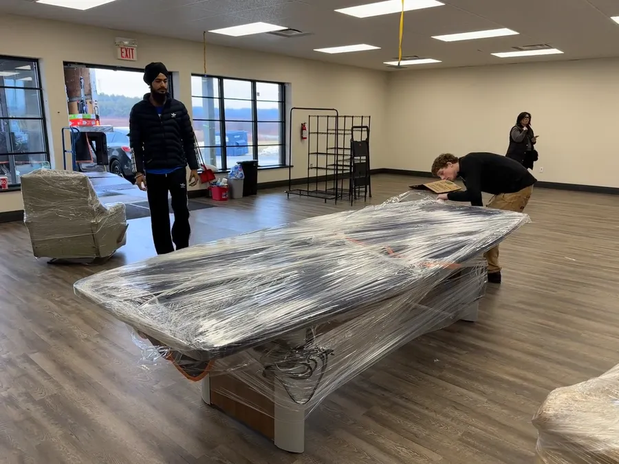 Optimum crew members wrapping office furniture for transport